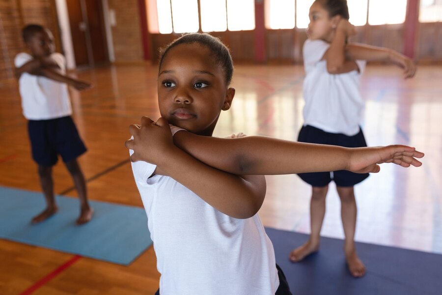 Une écolière fait du yoga sur un tapis de yoga à l'écoleUne écolière fait du yoga sur un tapis de yoga à l'école